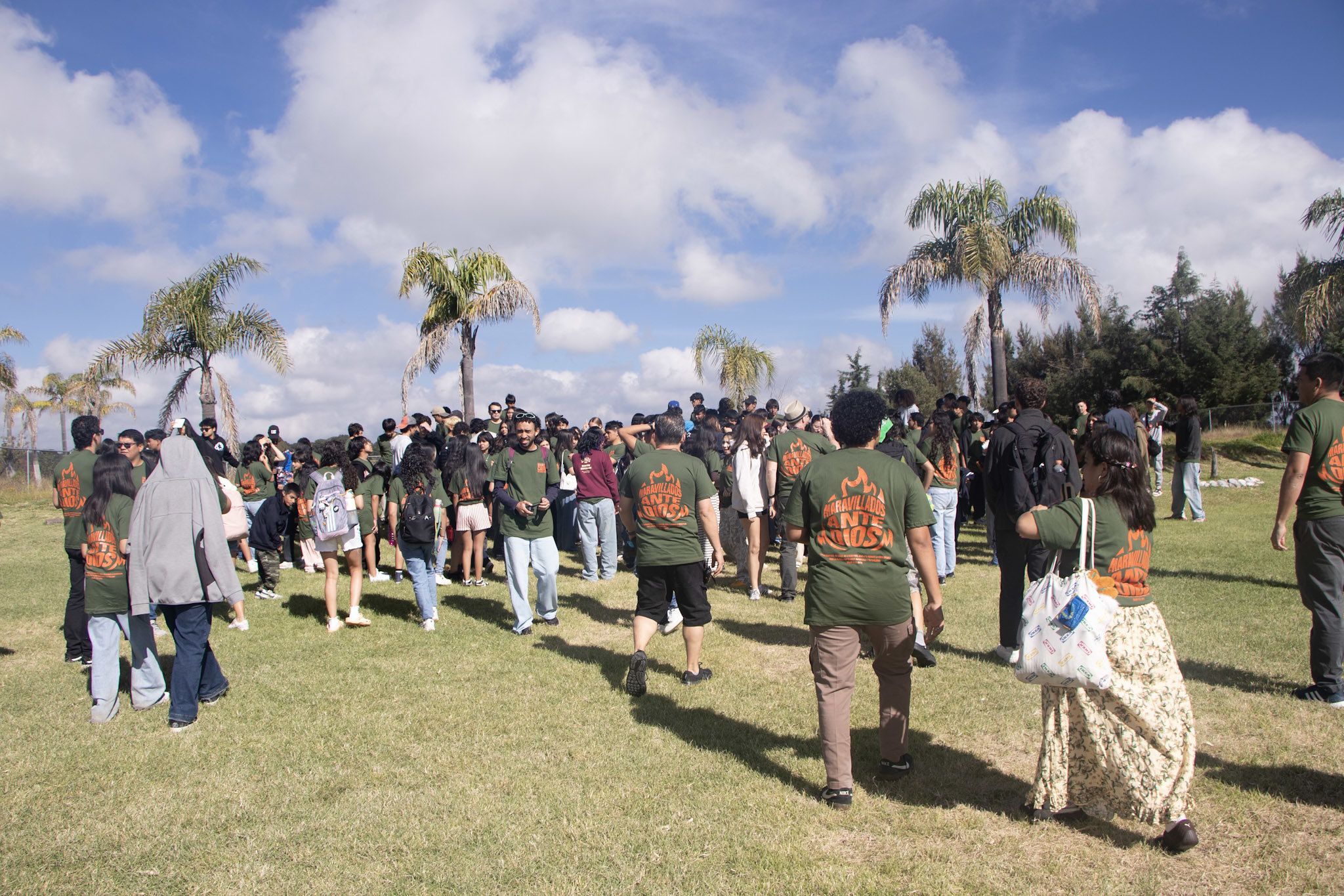 The Mexico camp crowd walking out across the lawn under a big sky