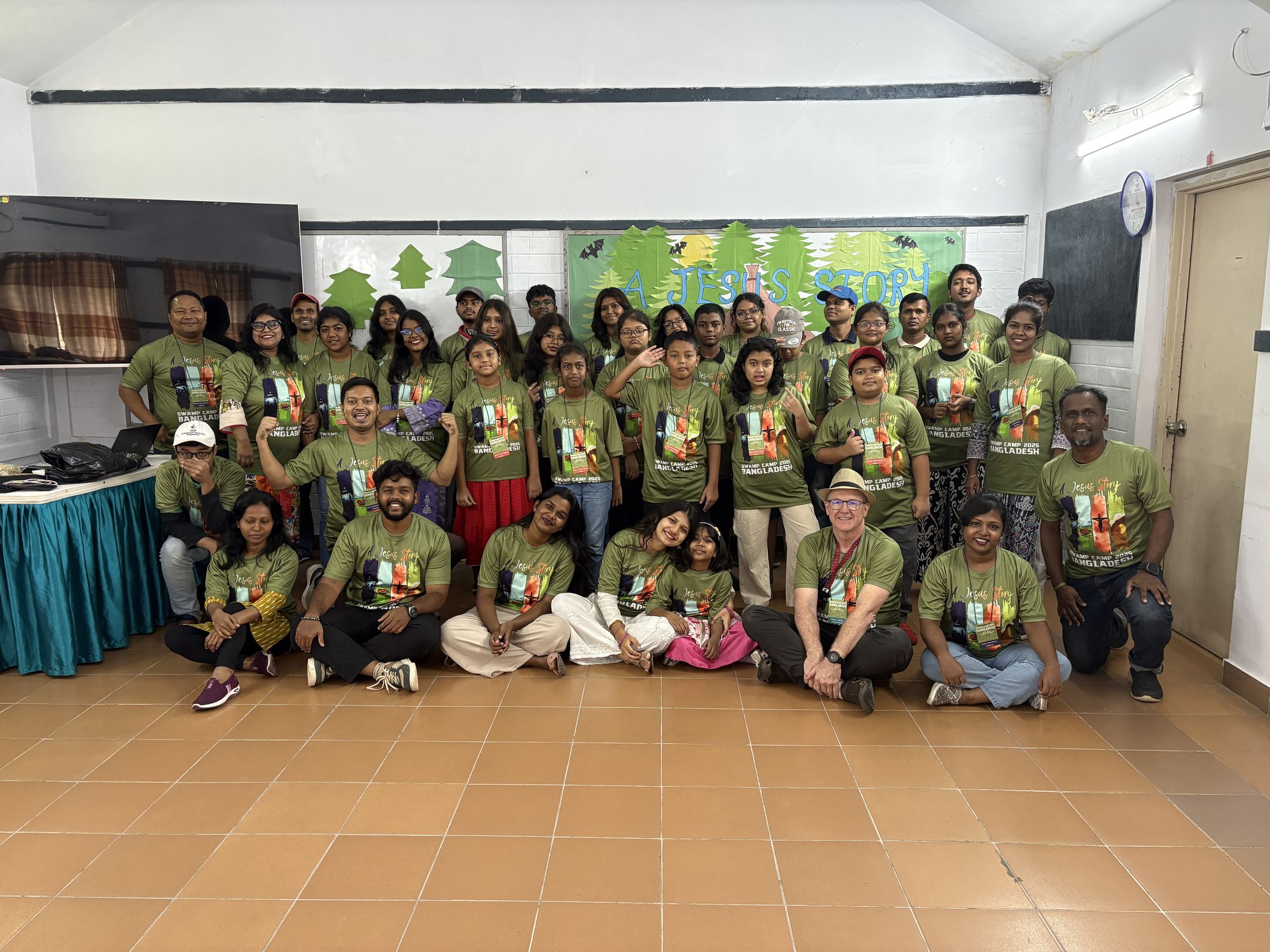 The whole of Swamp Camp Bangladesh in green camp shirts, gathered for a group photo