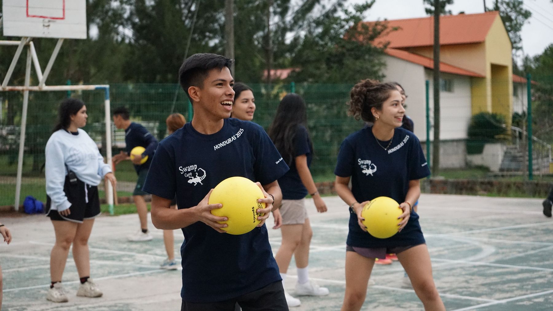 A counselor grinning with a dodgeball in hand